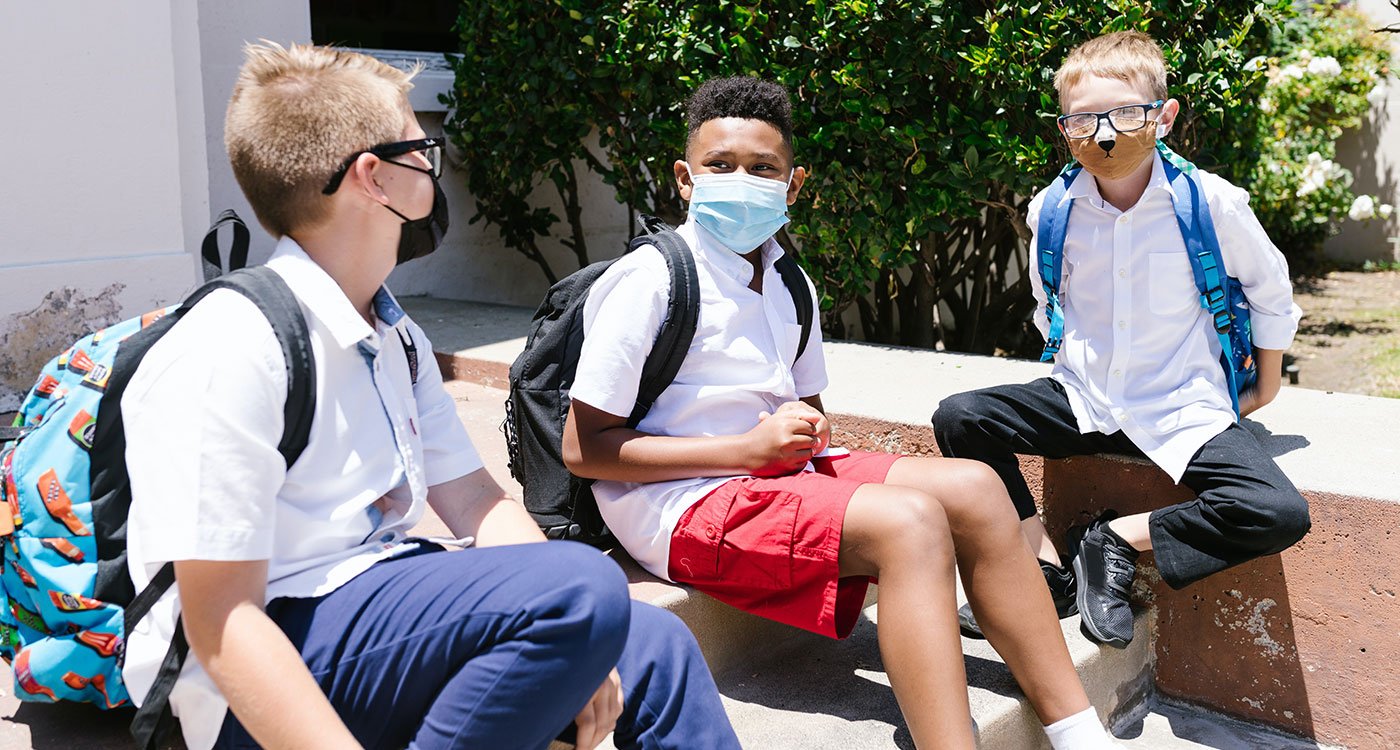 School boys sitting together with masks on