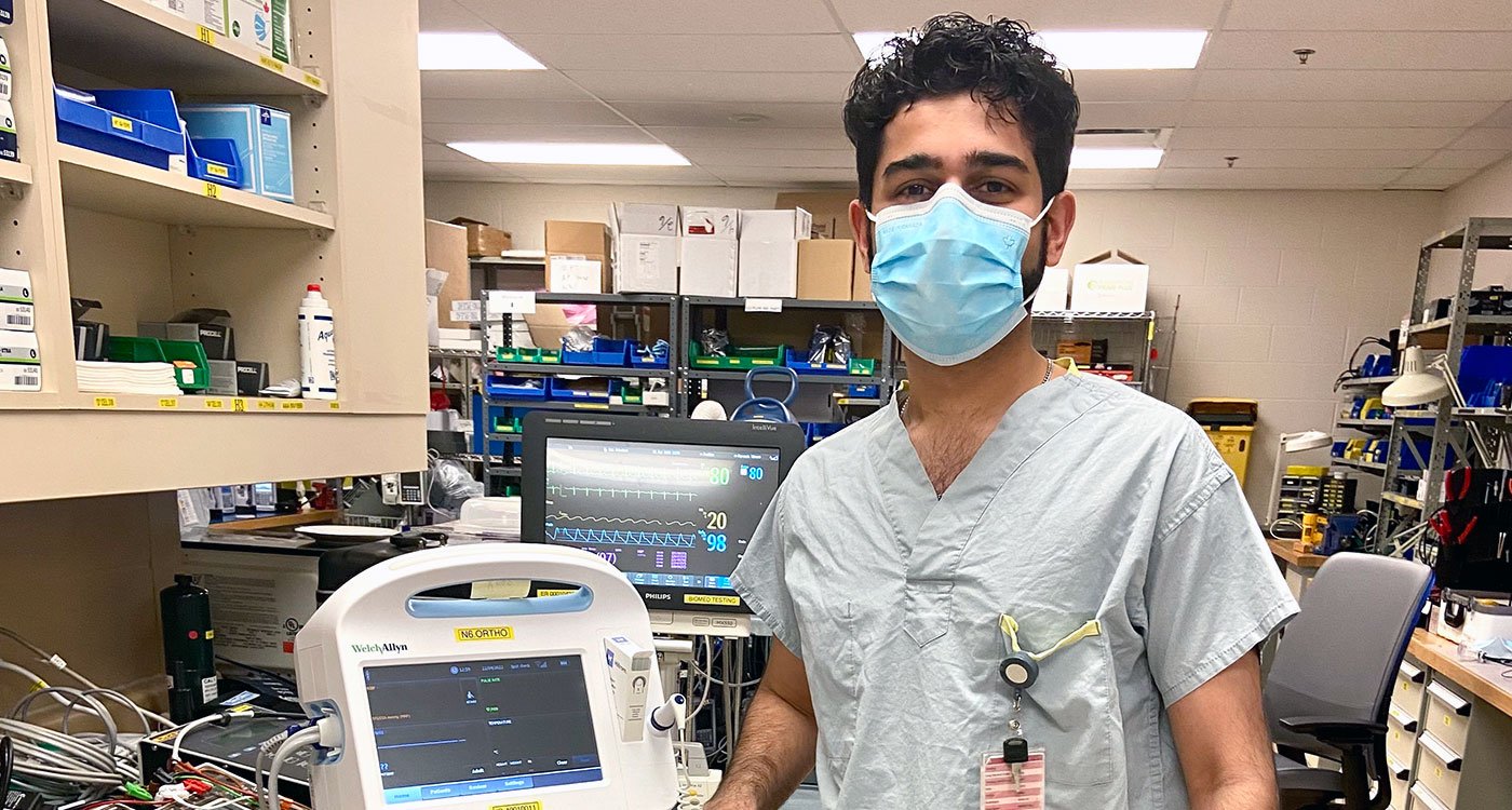 Aakashdeep Dhillon, Biomedical Technologist, stands with a piece of medical equipment