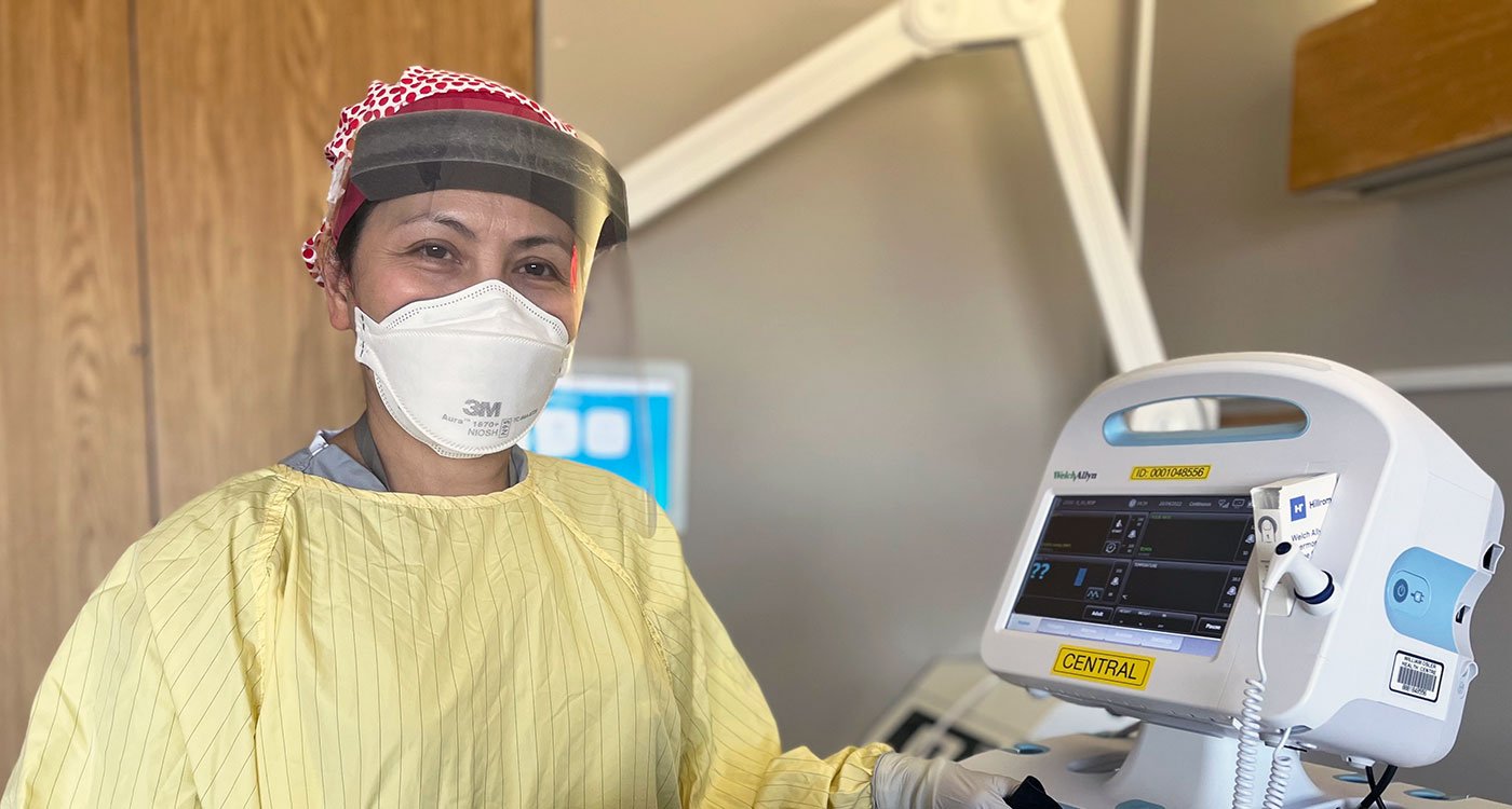 Maria, an RN in the Respirology Unit at Etobicoke General Hospital, poses with a vital signs monitor