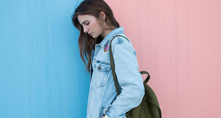 Teenage girl walking with backpack looking sad