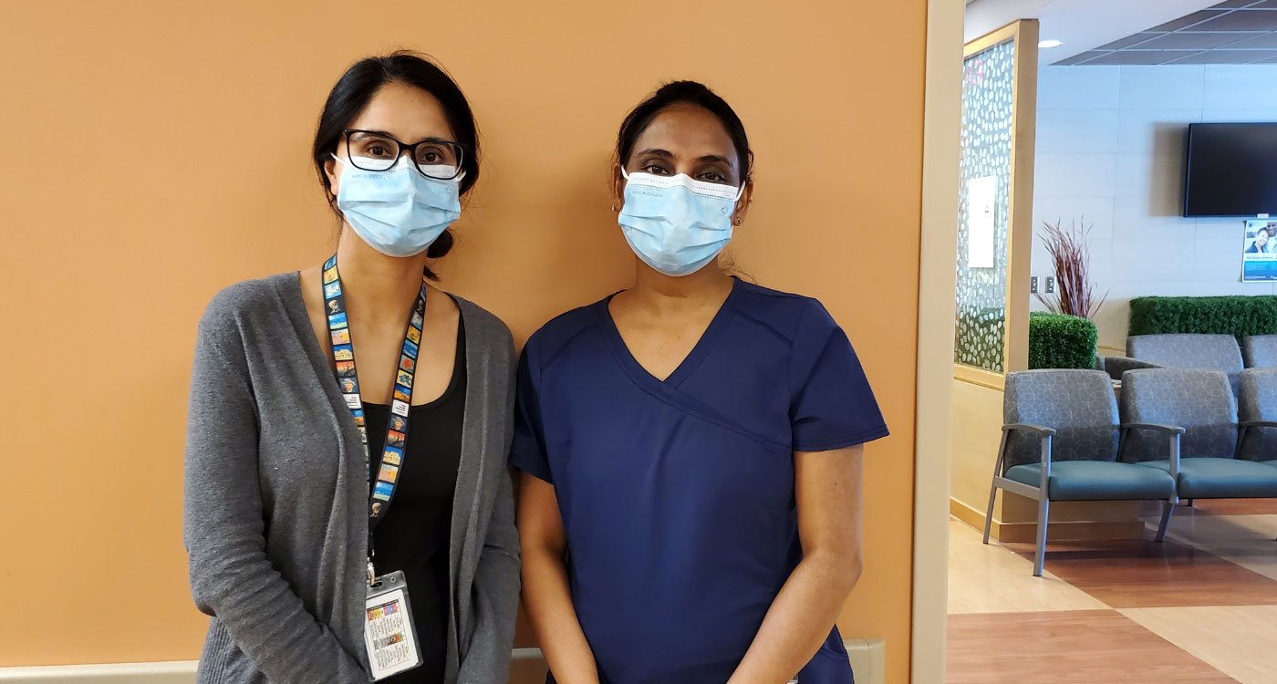 (l-r): Harprit, Social Worker, and Diana, Registered Nurse, stand together in the Oncology Unit