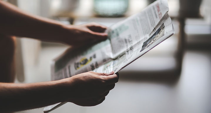 A person is reading a newspaper