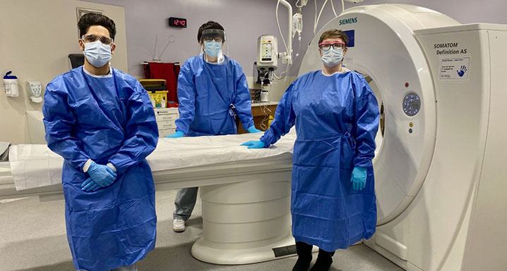 Diagnostic Imaging staff posing with a CT scanner