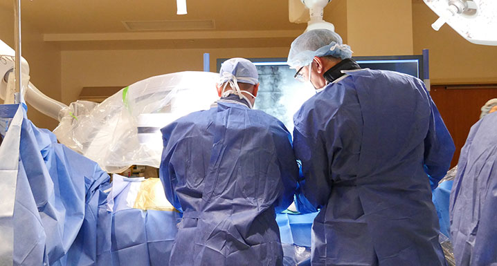 Two physicians performing surgery on a patient