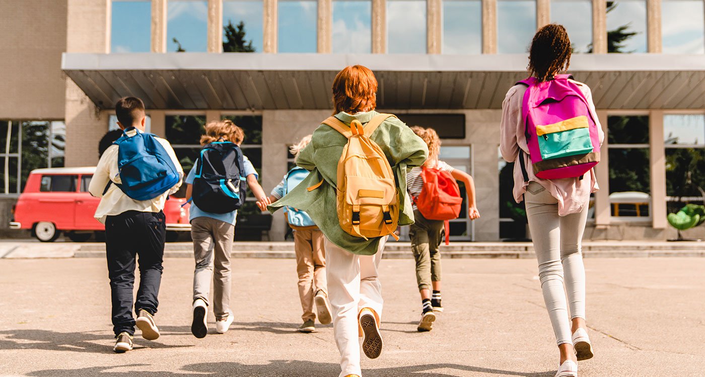 Children running towards their school