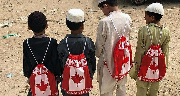 Four boys wearing Canada backpacks they were gifted from the 2019 Global Health tour group