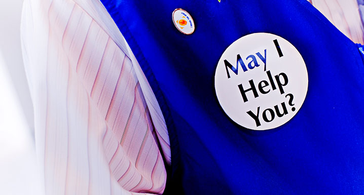 Pin on volunteer vest that reads may I help you?