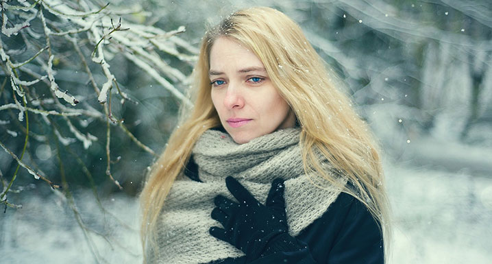 Woman walking outside in the cold looking sad