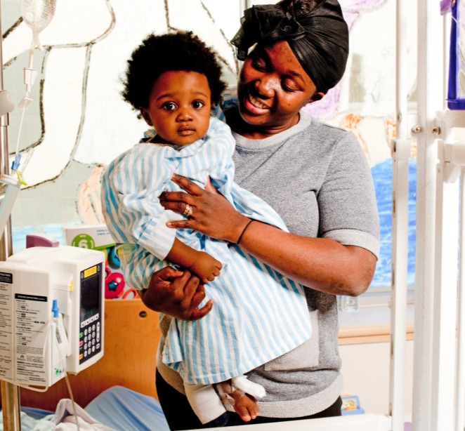 Mother holding her toddler in a paediatric room