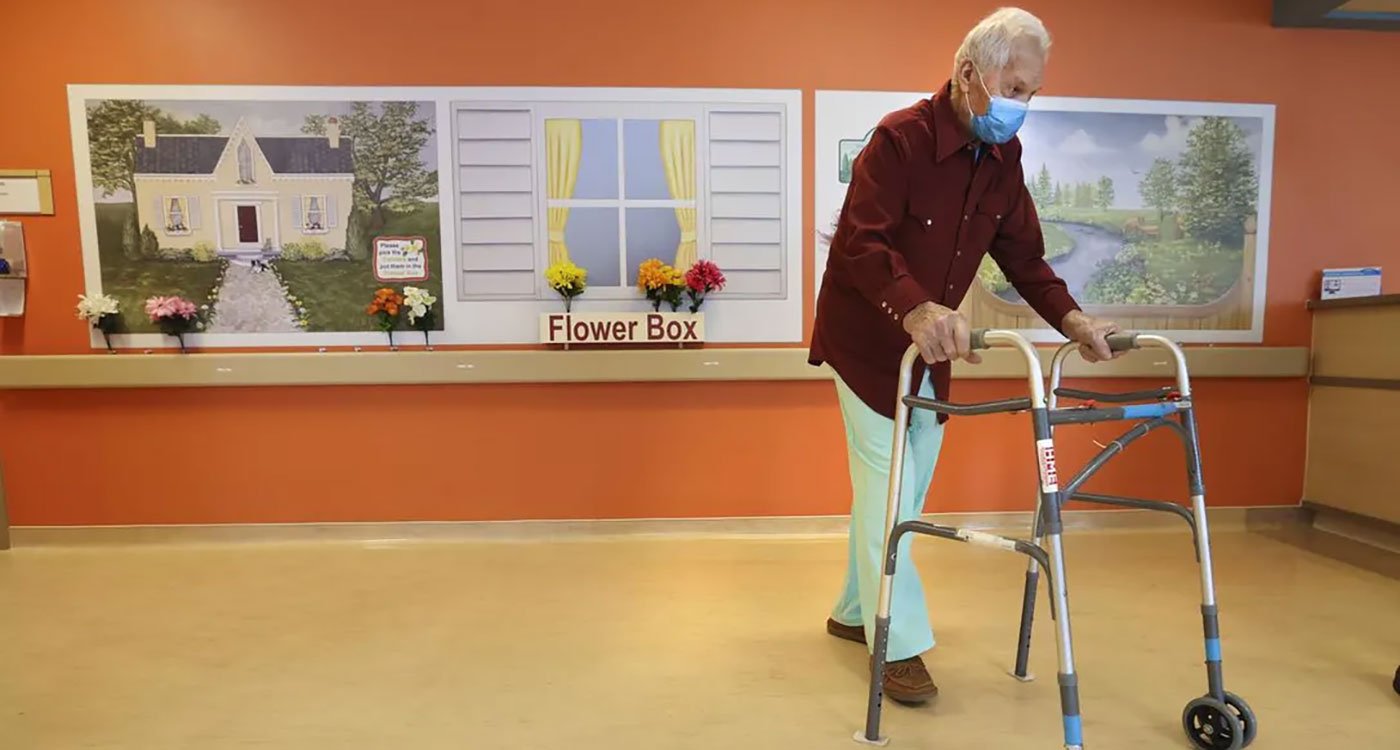 Patient walks past an interactive wall painted like a garden