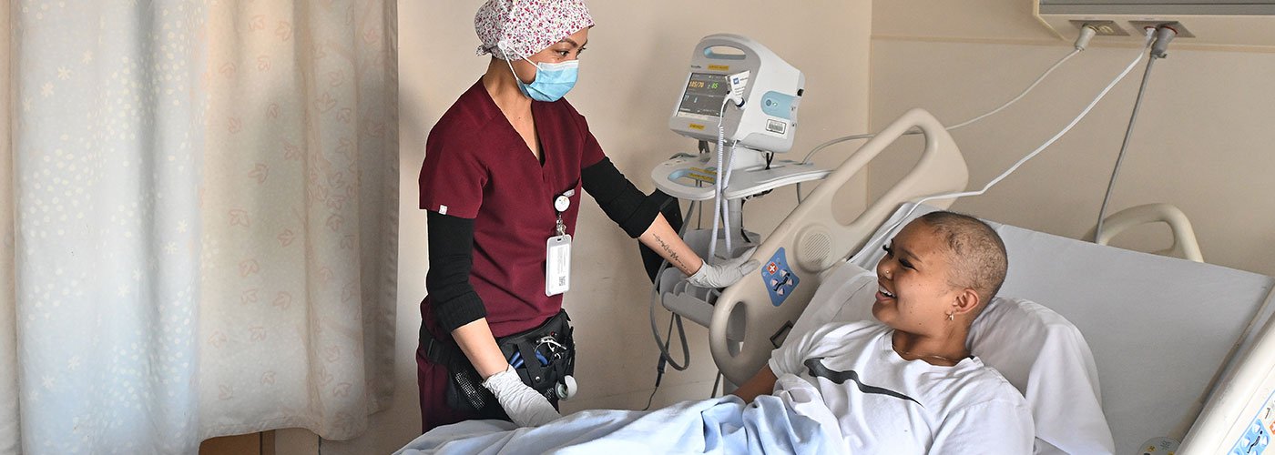 A nurse cares for a patient at the bedside