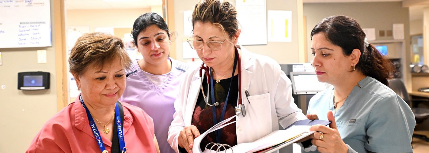 A clinical manager shares charts with staff