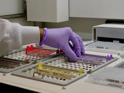 An Osler laboratory technician loads samples into the Next Generation Sequencing machine