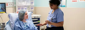 Clinician talks with surgical patient in stretcher